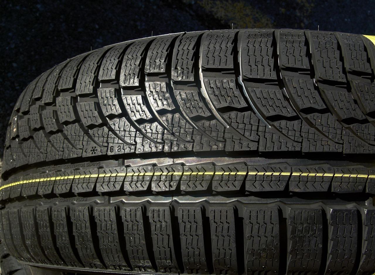 Mobile tire technician swapping a flat tire at the roadside in Miami-Dade