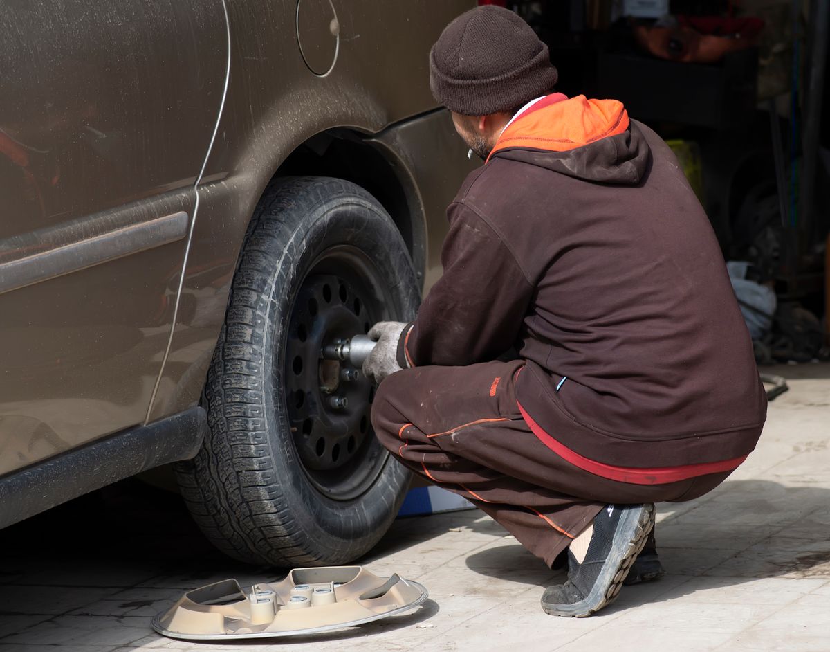 Mobile tire technician servicing a car tire